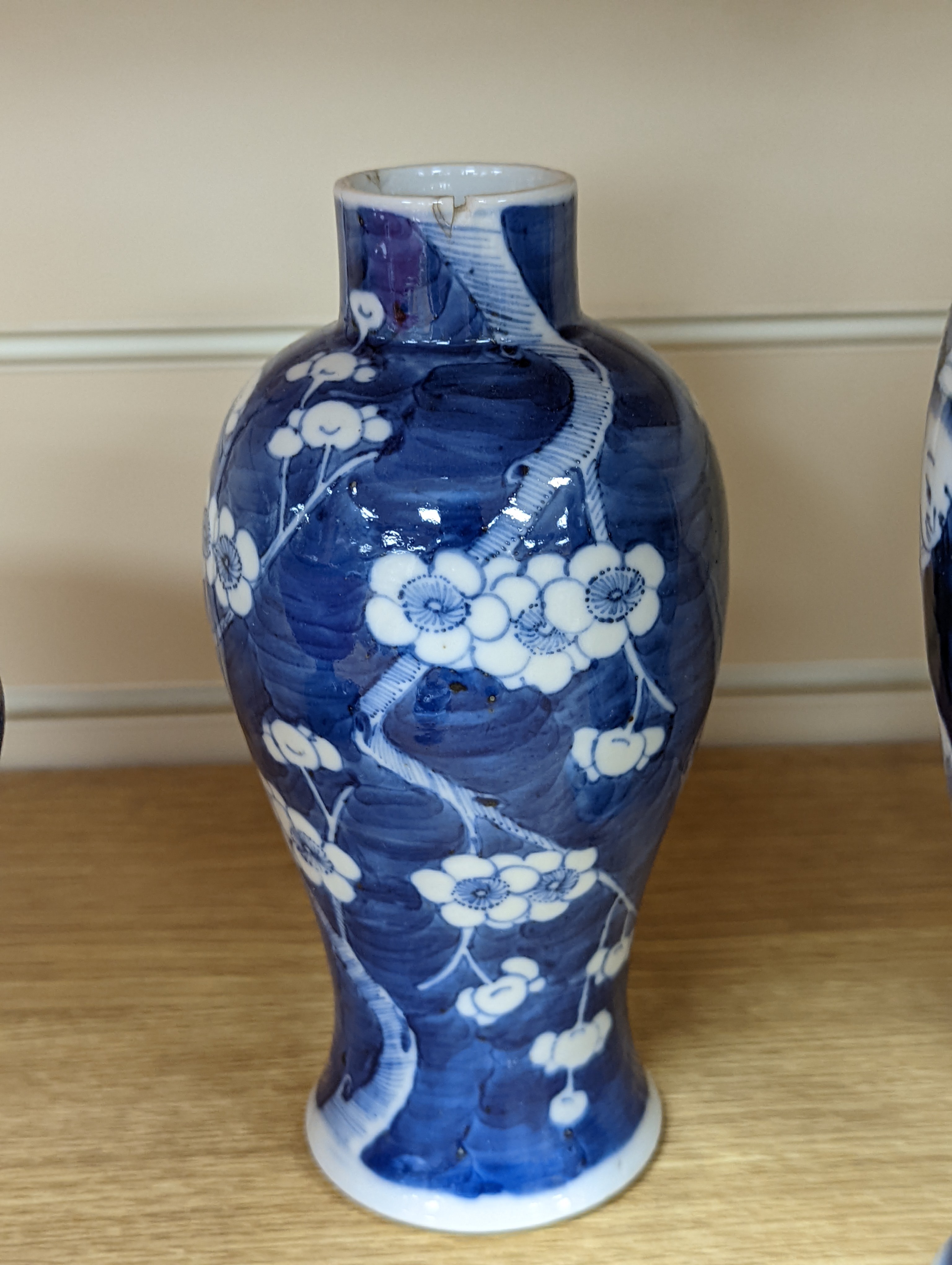 A pair of 19th century Chinese blue and white vases, a prunus vase and cover and a similar jar (4), pair of vases 24 cms high.